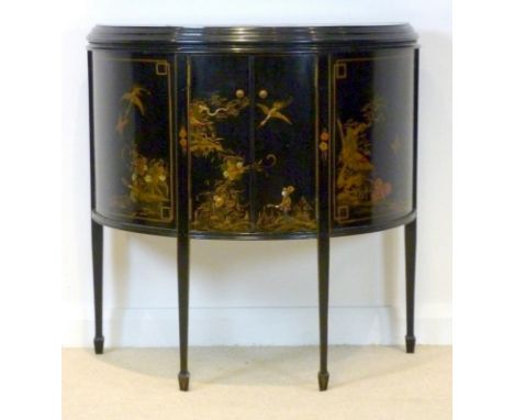 A Japanese black lacquered demi lune sideboard, circa 1910, with two doors enclosing a single shelf, decorated with cranes an