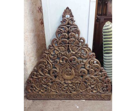 A 1.02m wide old Indonesian decorative panel of triangular form with ornate pierced scroll decoration and central motif - old