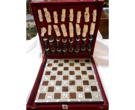 A vintage cased chess set with hand worked resin pieces and a wooden chess board with checkered mother-of-pearl inlay and oth