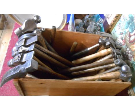 A wooden box containing a quantity of vintage hammers