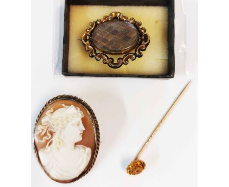 A marked 15ct topped stick pin, a gilt framed swivel mourning brooch with plaited hair panel and a late shell cameo brooch