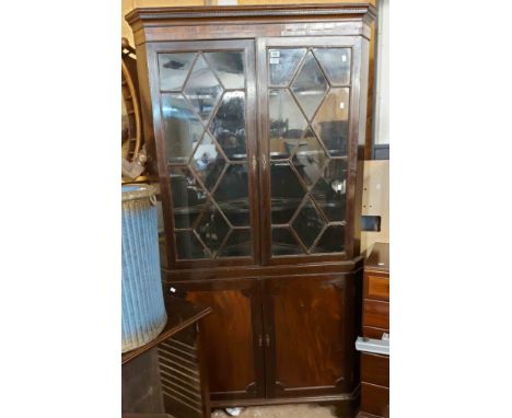 A 1.05m 19th Century mahogany corner cabinet with shelves enclosed by a pair of beaded glazed panel doors over pair of cupboa