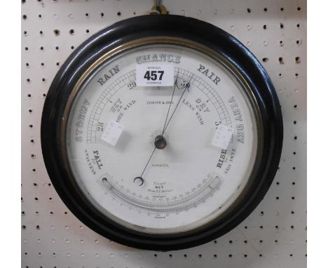 An antique ebonised framed wall barometer/thermometer with printed dial marked for Cooper &amp; Son, Norwich, with aneroid wo