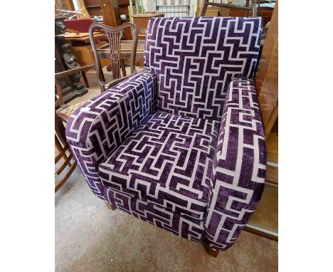 A modern armchair with purple machine tapestry upholstery