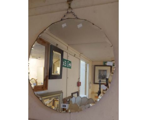 A vintage frameless wall mirror with decorative cut border to the circular plate