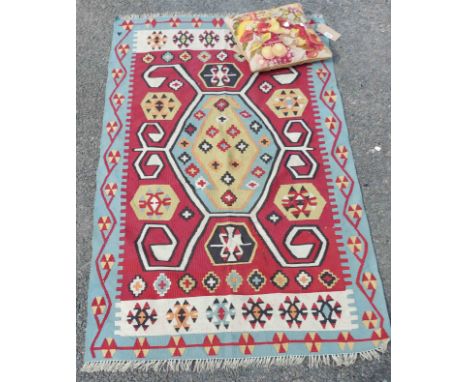 A modern kelim with polychrome motifs within a blue border - repair - 1.72m X 1.05m - sold with a tapestry cushion