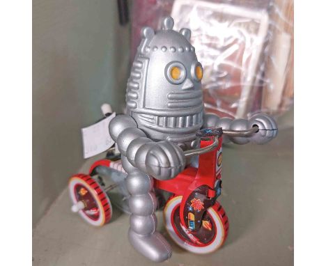 A modern tin plate clockwork toy, depicting a robot on tricycle