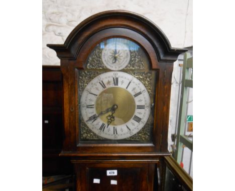 A vintage oak longcase clock with brass and silvered effect arched dial with triple chiming regulator to top playing St. Mich