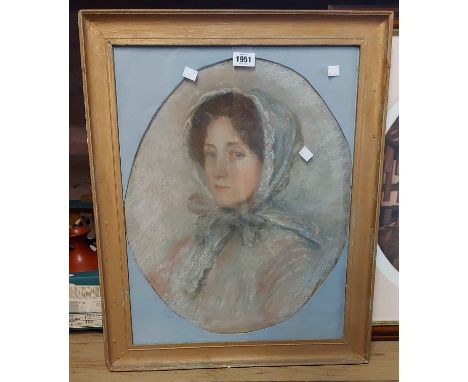 An old gilt framed and oval slipped pastel portrait of a woman wearing a lace bonnet