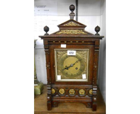 A late 19th Century oak cased mantel clock of architectural design with inset roundels, brass dial and eight day gong strikin