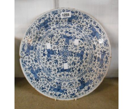 An 18th Century English delftware charger with painted blue stylised leaf decoration