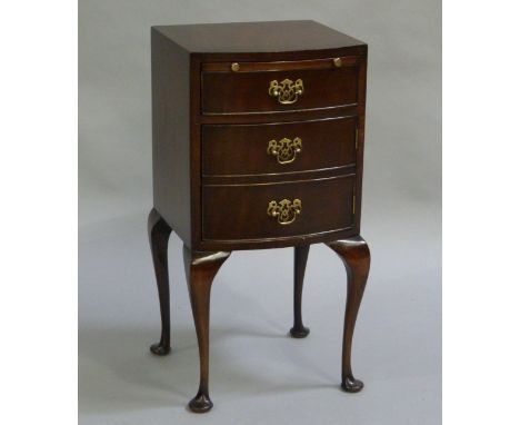 A mahogany bow fronted bedside cabinet having a pull slide above a twin dummy drawer fronted cupboard door on slender cabroil