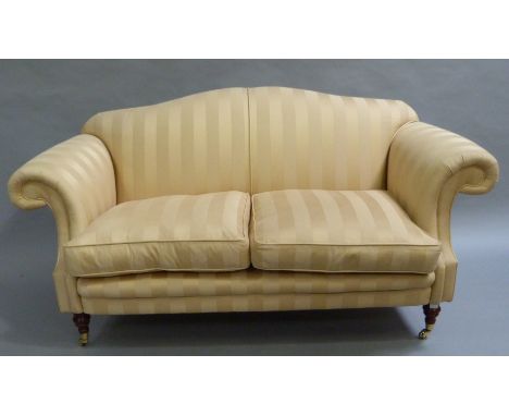 A pale yellow stripe two seater sofa on turned legs, caps and castors 