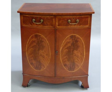 A mahogany and satinwood banded bow fronted two door tv/hi-fi cabinet, the doors modelled as fake drawers over a oval veneer 