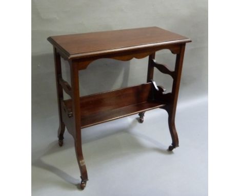 An early 20th century mahogany table book rack of rectangular outline with shaped apron with book trough undertier on square 