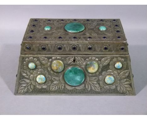 An Arts and Crafts pewter jewellery box of tapered oblong form set with blue glass and glazed ceramic cabochons 