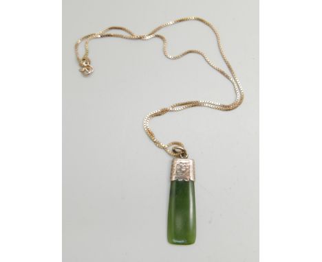 A 9ct gold mounted jade pendant (loop marked) on a 9ct gold chain, 7.3g total weight 