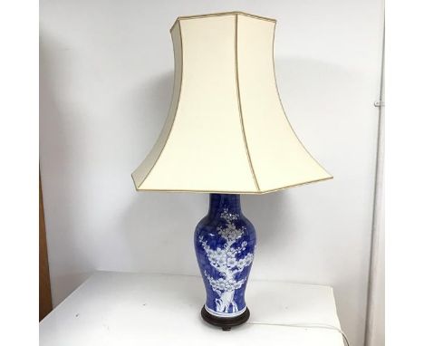 A Chinese vase style lamp, the baluster base with cherryblossom tree decoration, on a wooden four footed stand, complete with