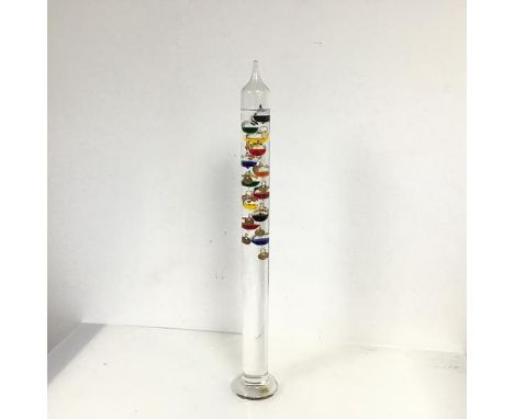 A Galileo thermometer with twelve internal bobbles, with coloured liquids, measuring from 15 degrees to 26 degrees (h.62cm)