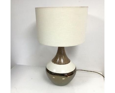 A 1970s style table lamp, the ceramic base of bulbous form tapering to a slender neck, with linen shade (h.60cm to top of sha