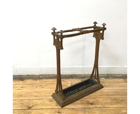 An Art Nouveau cast iron stick stand, c.1900, the patinated gilt frame incorporating stylised floral motifs, with two divisio