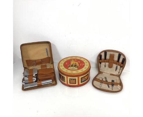 A Peek Frean &amp; Co. Ltd., London circular tin box (h.10cm x d.21cm), a pigskin manicure set and a cow hide gentleman's toi