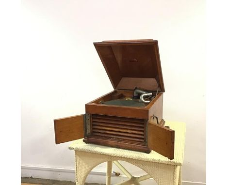 An HMV oak cased wind up gramophone, the moulded hinged lid opening with HMV logo to base, record playing mechanism above a p