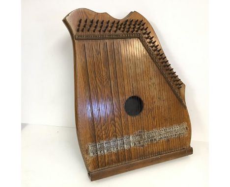 An early 20thc piano chord stamped Made in Germany each strings' notes marked by a scale along the base (53cm x 41cm x 5cm)