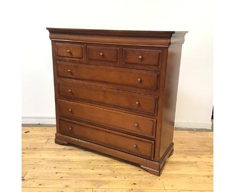 A reproduction cherrywood chest, the undulating frieze above  an arrangement of short and long drawers, raised on bracket fee