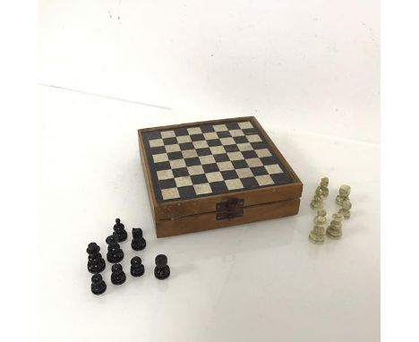 A travelling chess and backgammon set, the hinged lid with inset marble chessboard, opening to a fitted interior with complet