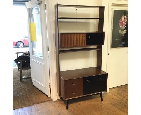 A G Plan wall unit with a single ebonised shelf over a cupboard with two sliding doors, on a chest fitted single fall front c