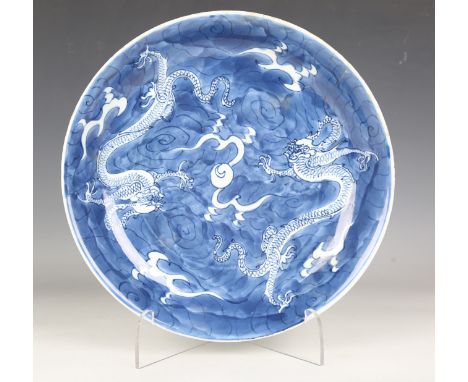 A Chinese blue and white porcelain saucer dish, Kangxi period, the interior painted with a pair of confronted dragons, flamin