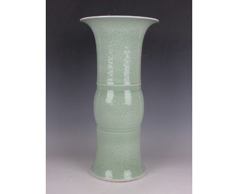 A Chinese Kangxi style celadon glazed porcelain beaker vase, mark of Jiajing but later, the exterior carved in low relief wit