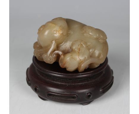 A Chinese yellow jade carving of a Buddhistic lion, Qing dynasty, possibly 18th century, modelled in a curved recumbent pose,