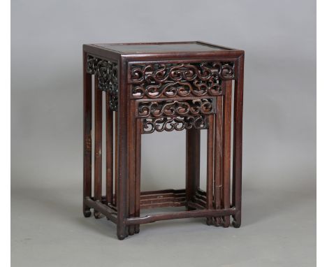 A Chinese hardwood quartetto nest of occasional tables, early 20th century, each rectangular panelled top with pierced scroll