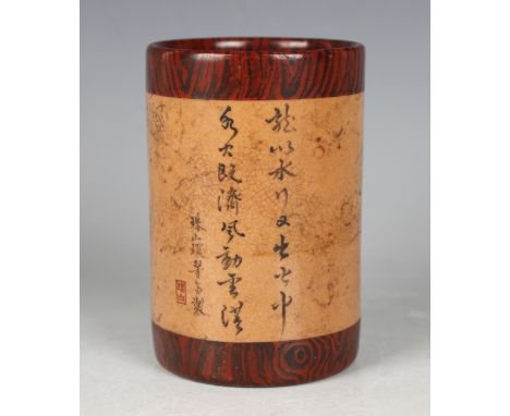 A Chinese faux bois porcelain brushpot, Qing dynasty, the cylindrical body painted en grisaille with a dragon and flaming pea