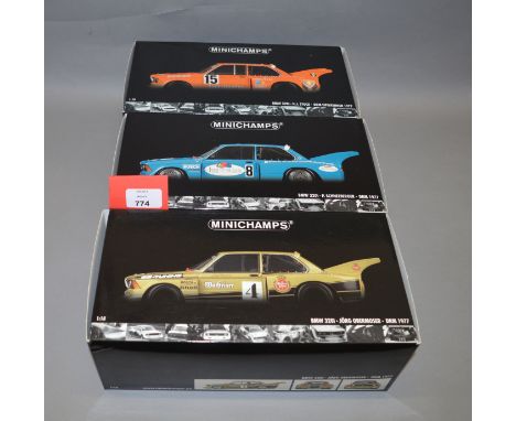 Three boxed Minichamps BMW 320i DRM 1977 diecast model cars in 1:18 scale, H.J. Stuck, Jorg Obermoser, and  P. Schneeberger. 