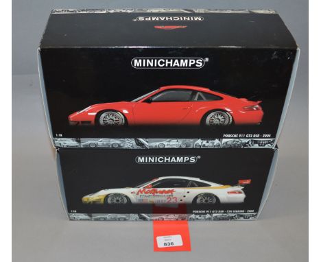 Two boxed Porsche 911 GT3 RSR (2004) diecast model cars in 1:18 scale, a road car in red  and a 12h Sebring car. Models appea