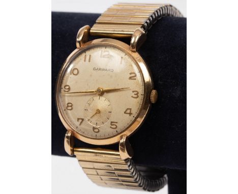 A gentleman's 9ct gold cased wristwatch, the dial inscribed Garrard, with articulated strap, awarded in 1929 by Esso for 25 y