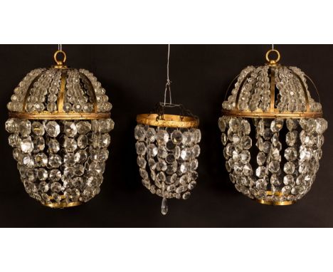 A pair of gilt metal pendant ceiling lights, hung trails of prismatic drops and a similar smaller light