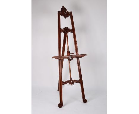 A large easel with adjustable picture rest and carved and foliate decoration, 198cm high