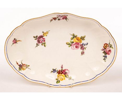 A Sèvres oval dish, circa 1770-1780, of lobed form, painted with scattered flower sprigs within blue and gilt line rim, inter