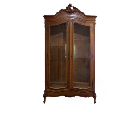 A French satinwood armoire, the moulded arch-top with open shell and scroll surmount and with fluted pillars to the sides, en