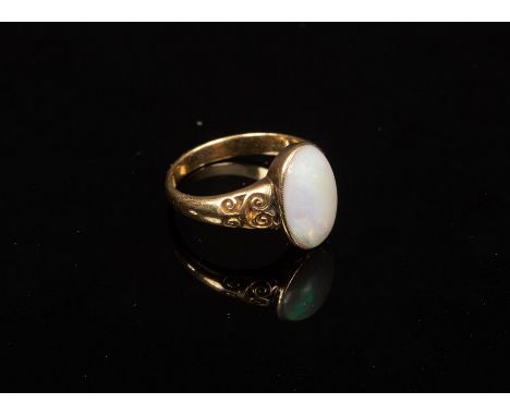 An opal set dress ring, the oval stone in an 18ct yellow gold setting with scroll shoulders, size M