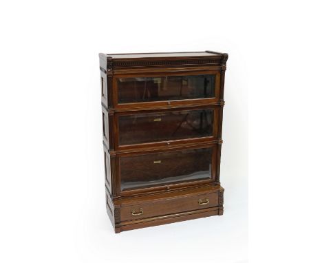 A mahogany Globe Wernicke bookcase, the dentil cornice above three glazed tiers flanked by pilasters, a drawer below, 90.5cm 