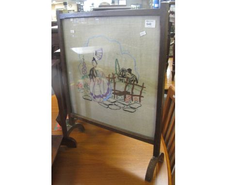 Tapestry fire screen depicting a lady by a cottage in oak frame.