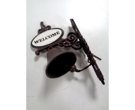 A cast iron welcome wall bracket with bell 