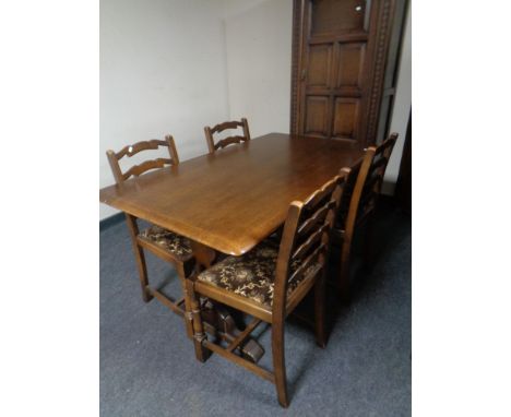 An Ercol elm and beech refectory dining table together with a set of four ladder back chairs in an oak finish, together with 