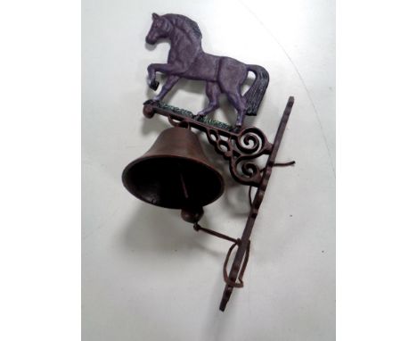 A cast iron wall bracket horse with bell 