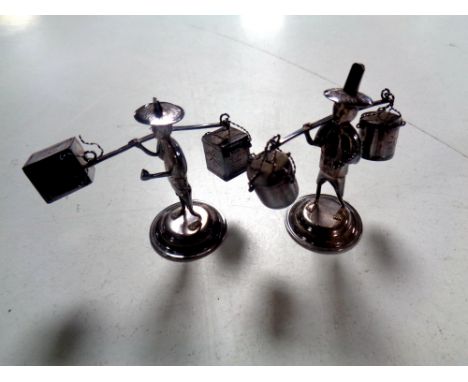 Two Chinese silver place card holders in the form of figures carrying baskets